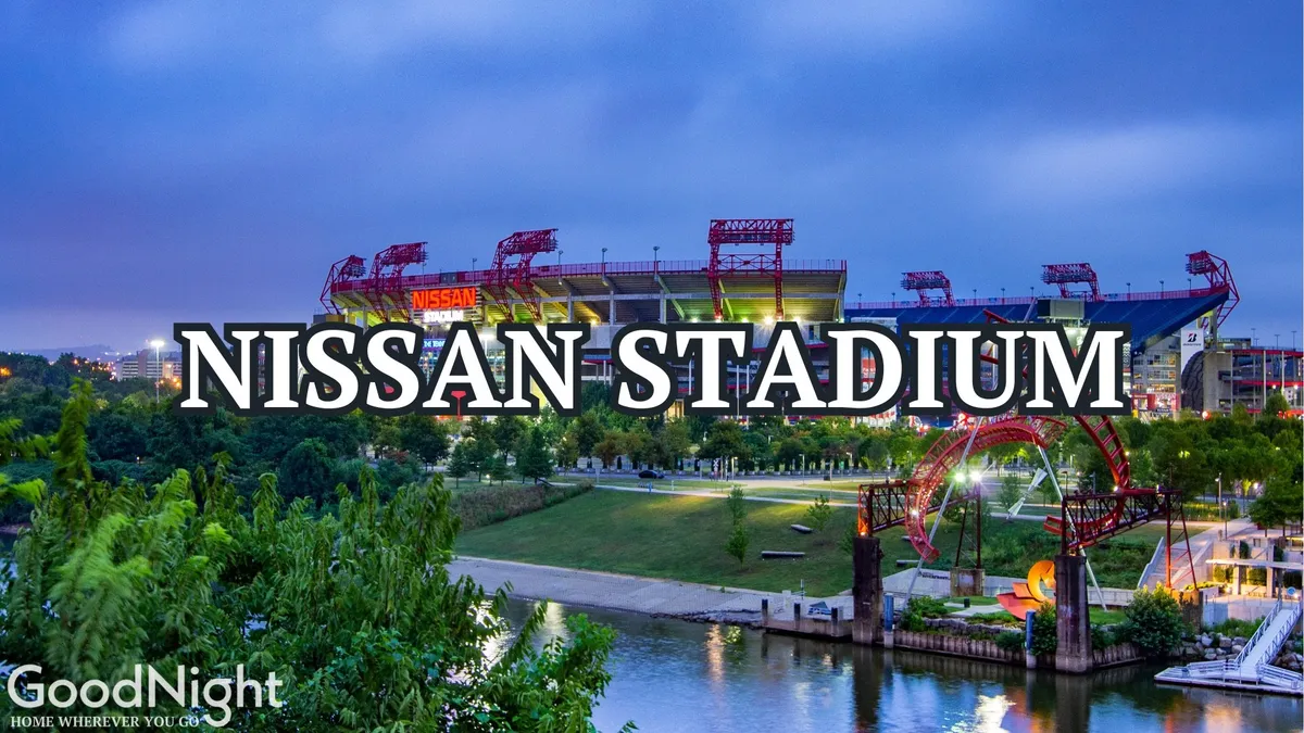 An exterior shot featuring Nissan Stadium across the river, with scenic park areas and pathways in the foreground. The arena and park environment showcase the excitement and variety of downtown activities within close reach.
