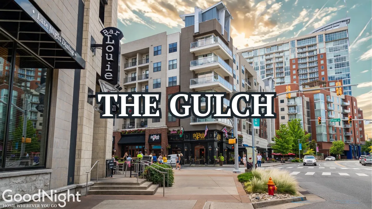 An exterior view featuring Bar Louie, The Gulch sign, modern apartment buildings, and bustling outdoor seating areas. This image highlights the blend of historic and contemporary elements found in the neighborhood, showcasing vibrant social spots and modern architecture alongside established urban landmarks.