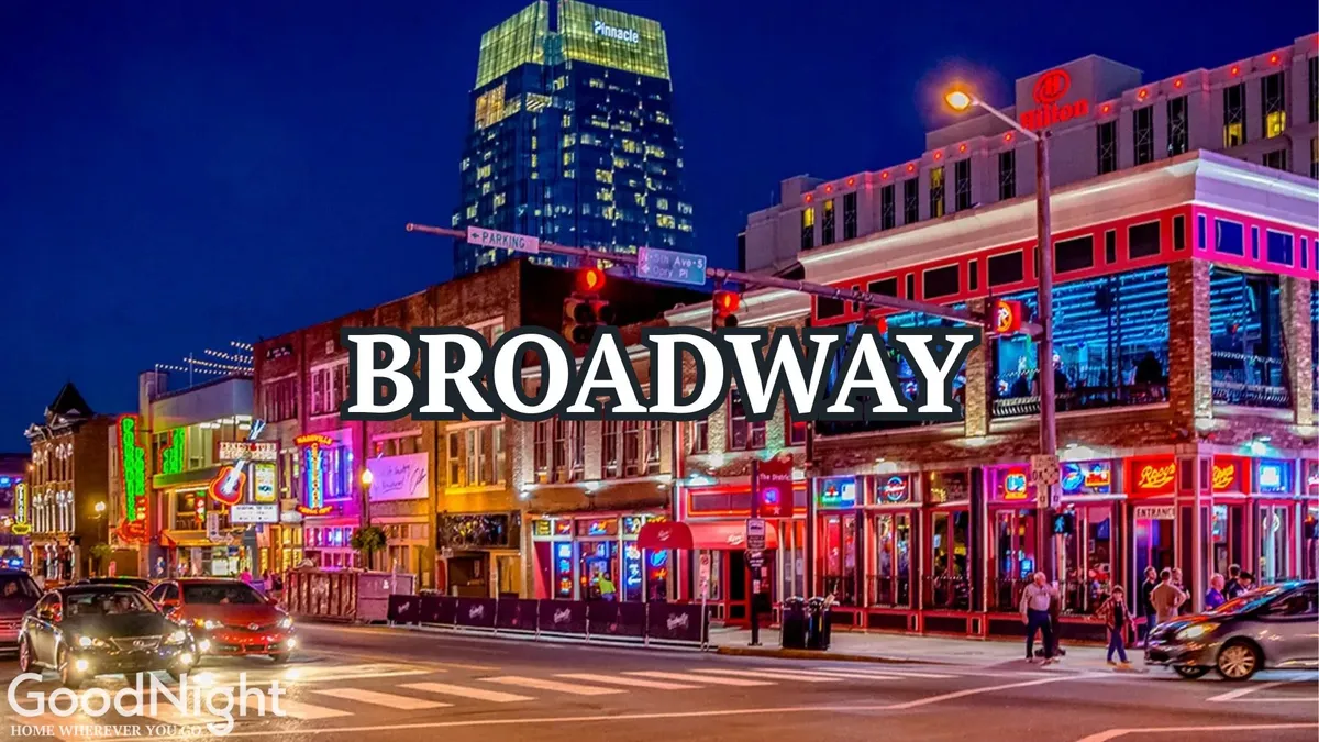 A bustling Nashville street scene illuminated by neon signs and lively nightlife establishments, with the city skyline in the background. The sidewalks are filled with people dining, listening to music, shopping, and soaking in the vibrant evening energy.
